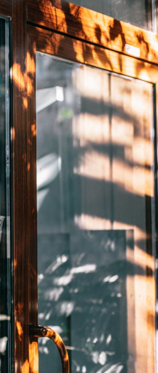 Late sun across the wooden frame and glass of a shop window.